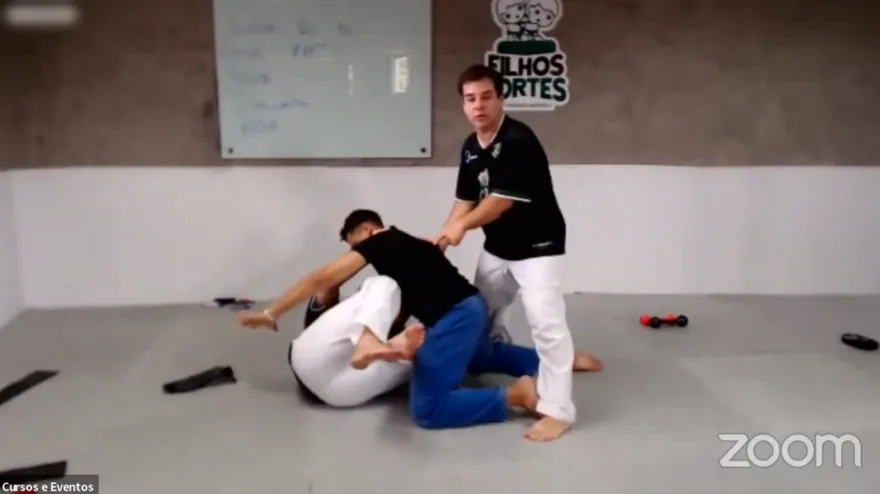 Dois professores demonstrando uma técnica no tatame durante a prática